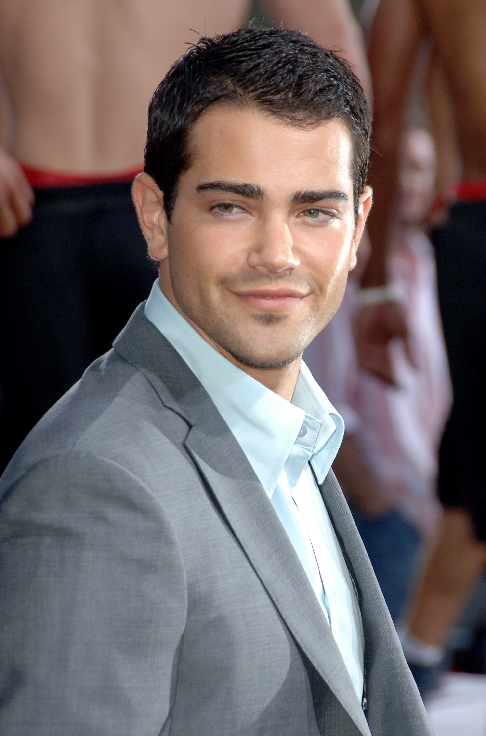 Person successful  a suit, smiling astatine  a reddish  carpet event