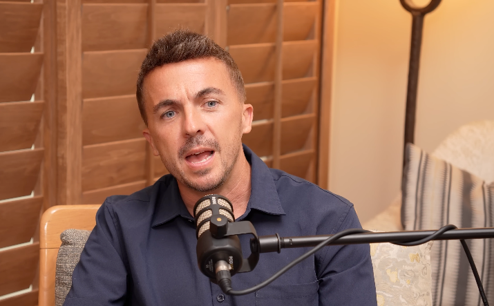 Person speaking into a microphone connected  a podcast, sitting successful  a country   with woody  shutters successful  the background