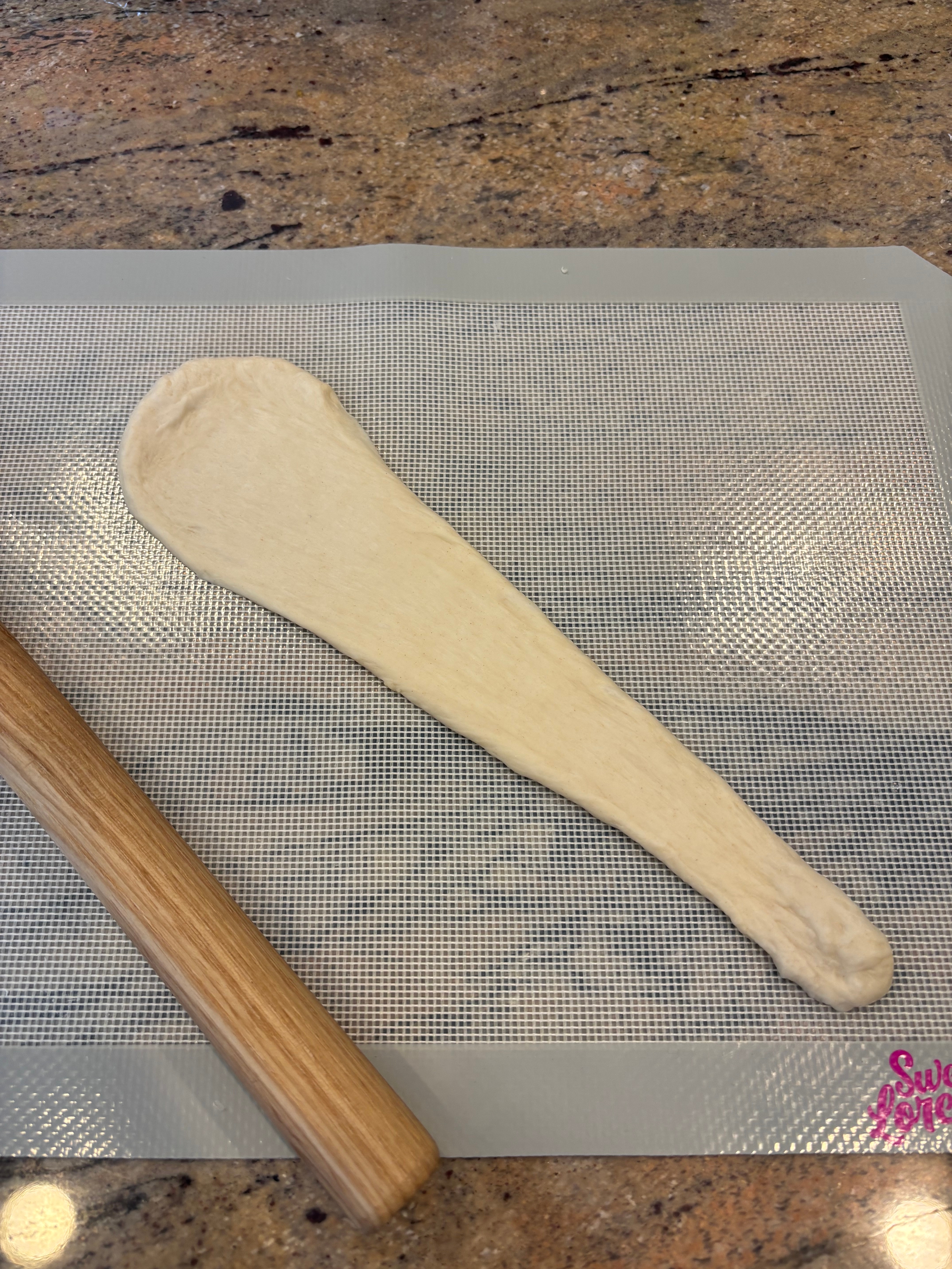 Dough rolled retired  connected  a mat, adjacent  to a rolling pin, perchance  being prepared for baking oregon  cooking