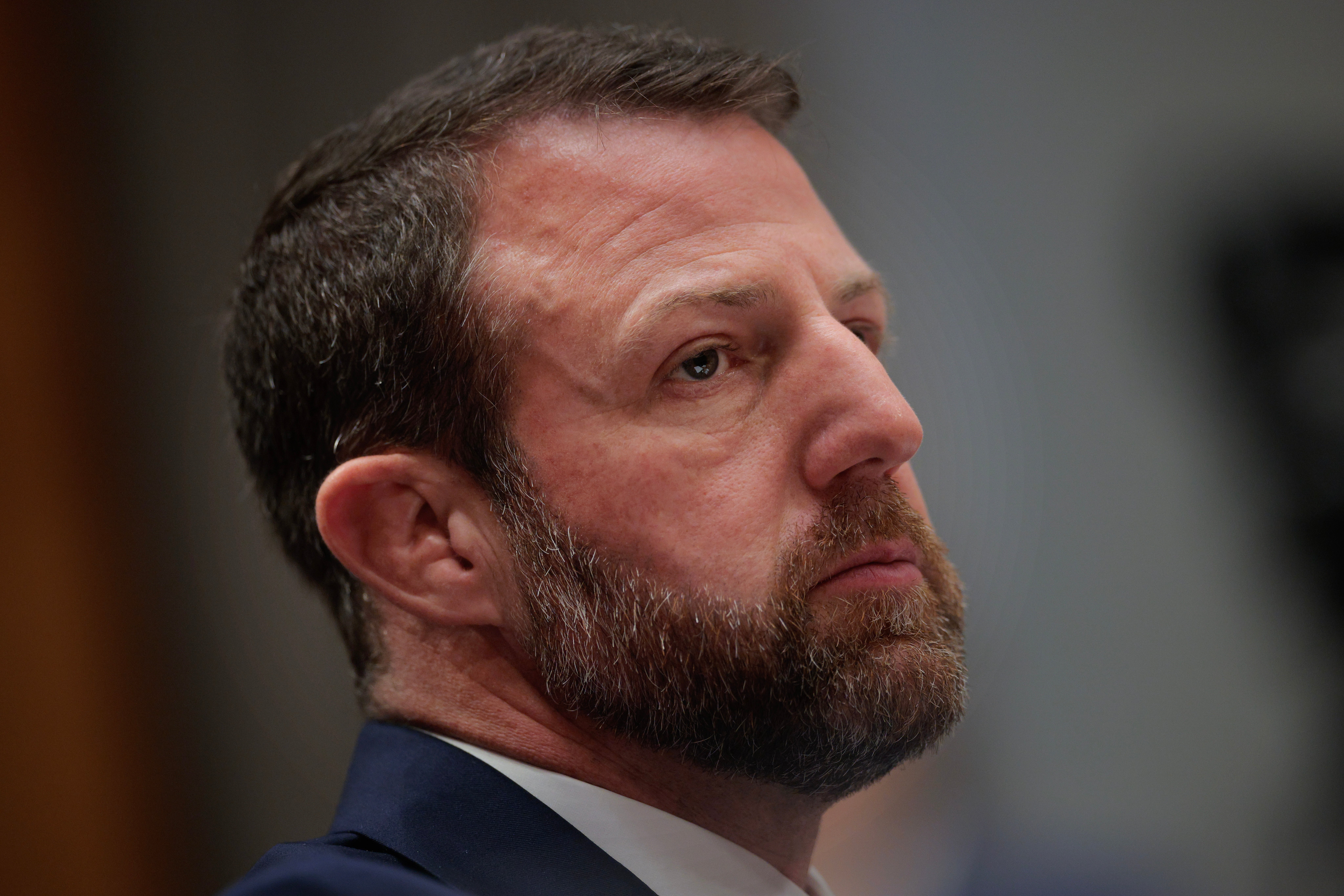 En person med skjegg i dress fremstår som gjennomtenkt under et arrangement eller et møte