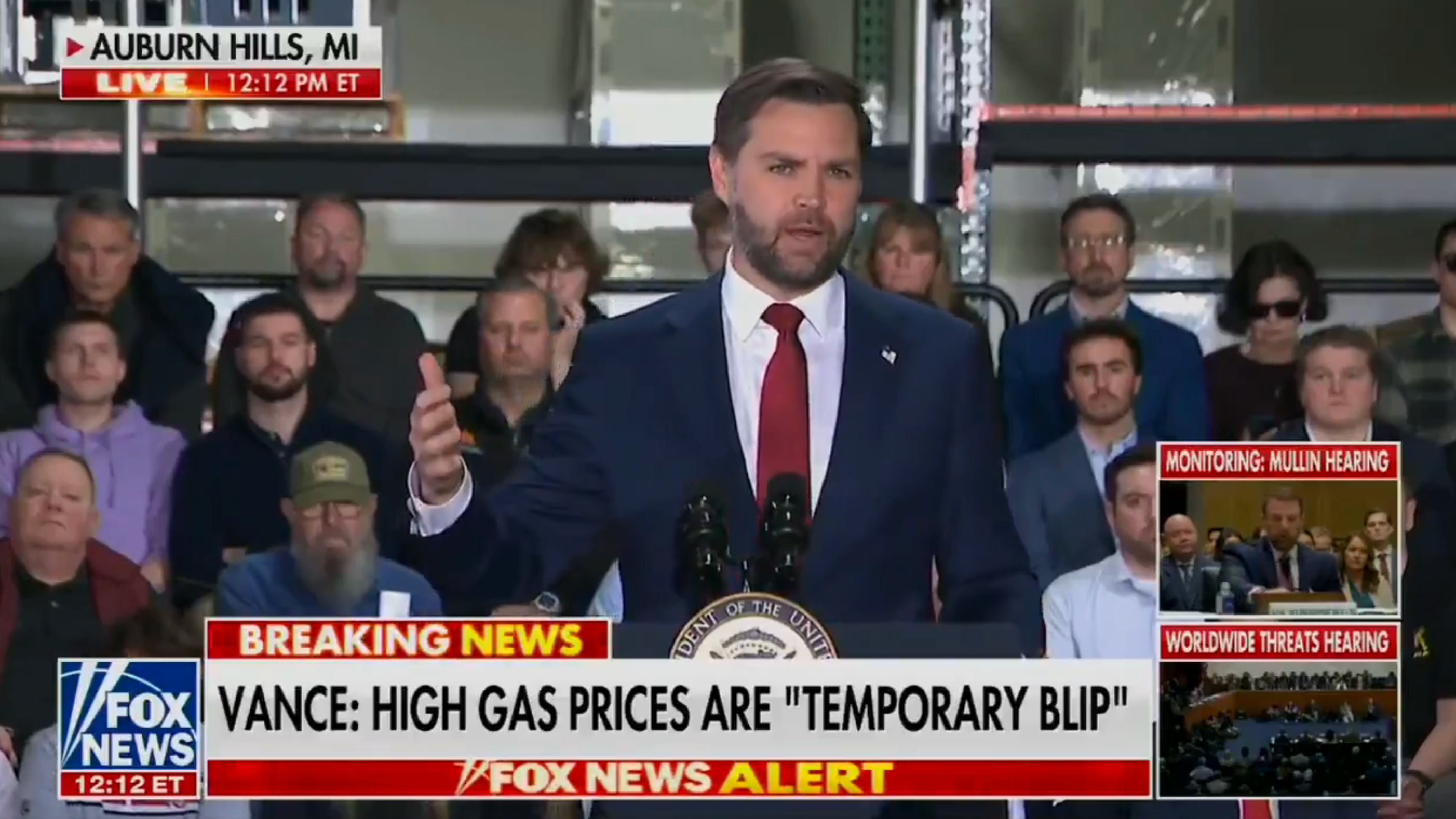 En mann snakker ved et podium med et publikum bak seg. Nyhetsbannere viser sitater og Fox News-logoer