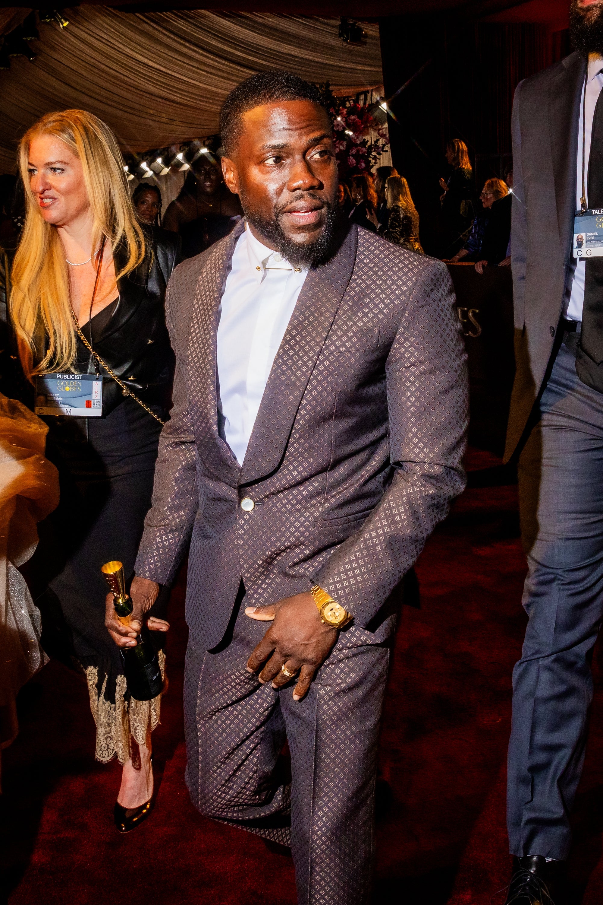 Mann i en mønstret dress som holder en pris, går på en rød løper