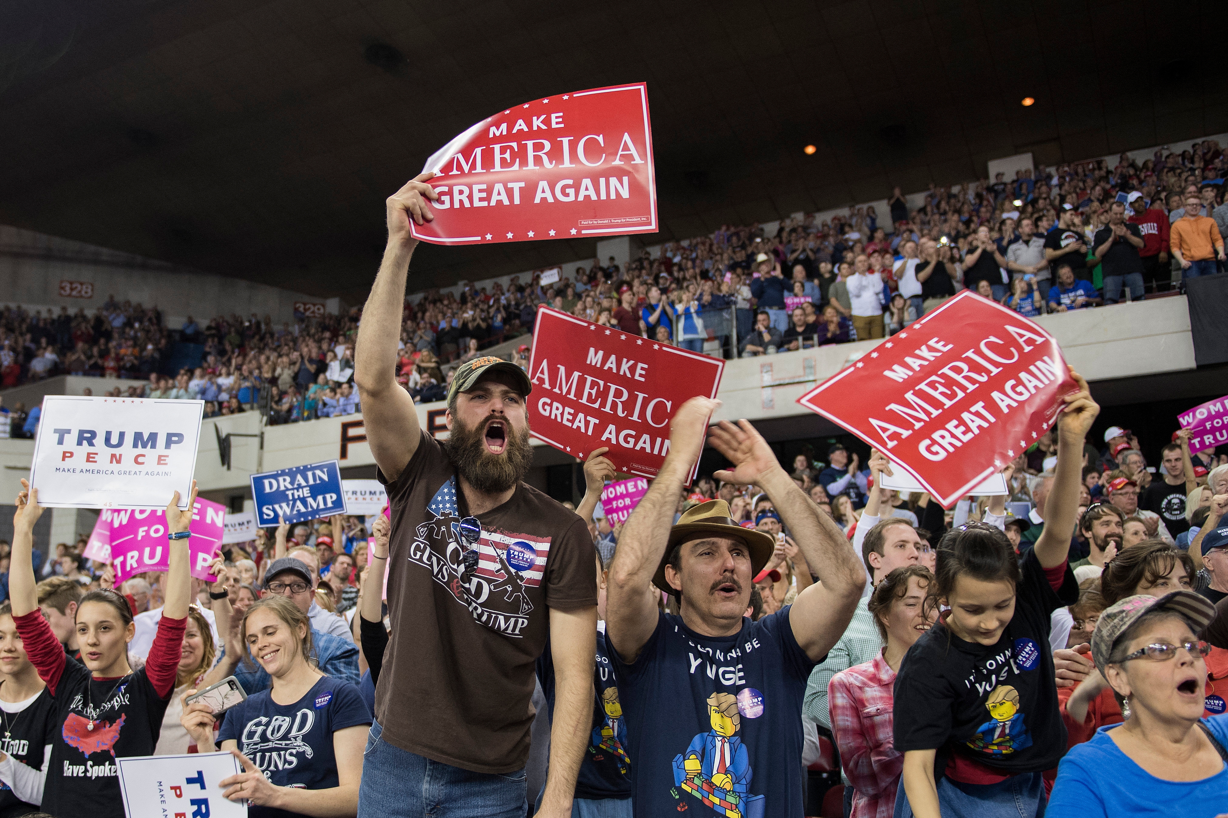 Crowd astatine a governmental rally, radical holding "Make America Great Again" signs, cheering enthusiastically