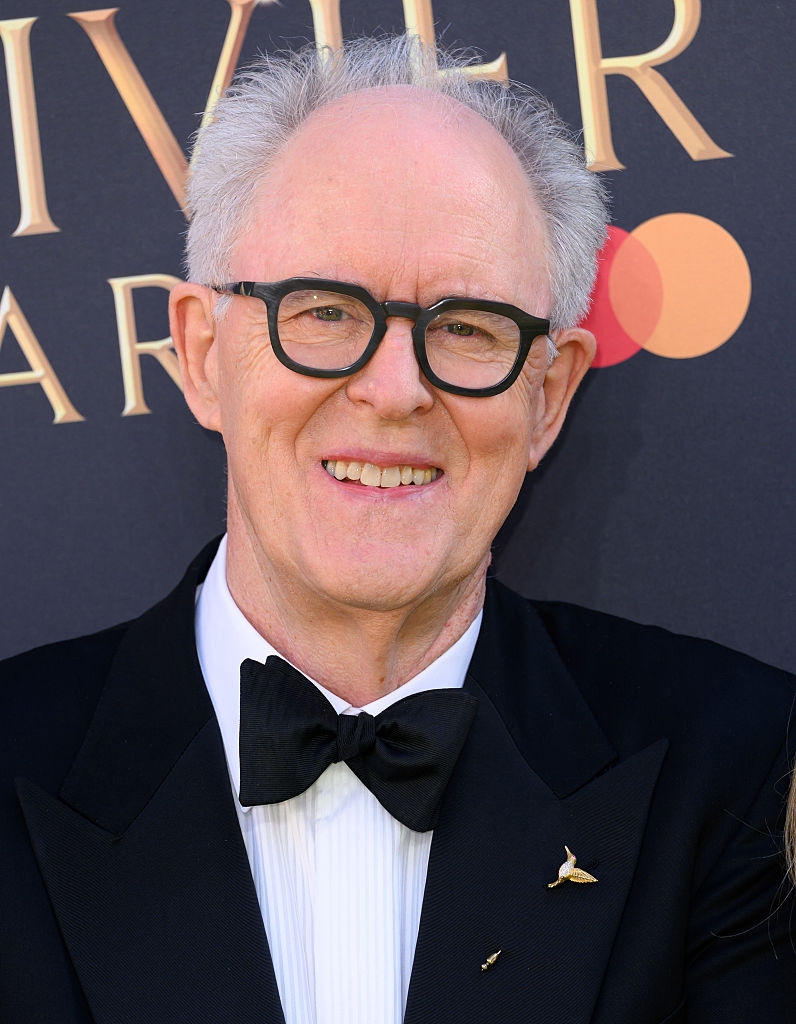Person smiling astatine  an event, wearing glasses and a achromatic  tuxedo with a bow tie