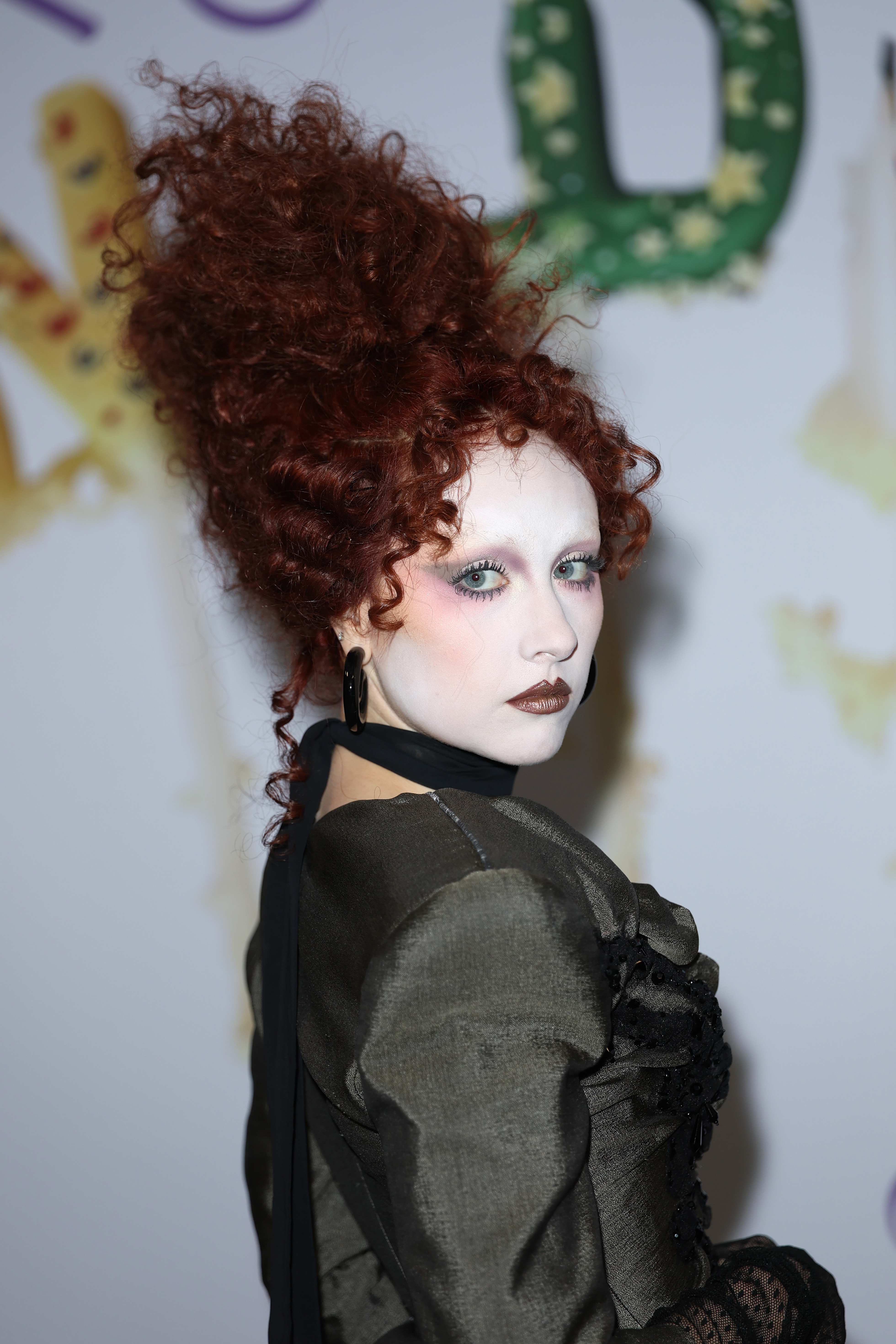 Person successful Victorian-inspired outfit with voluminous curled hairsbreadth attends an event. Dramatic constitution with acheronian lipstick and high-contrast oculus makeup