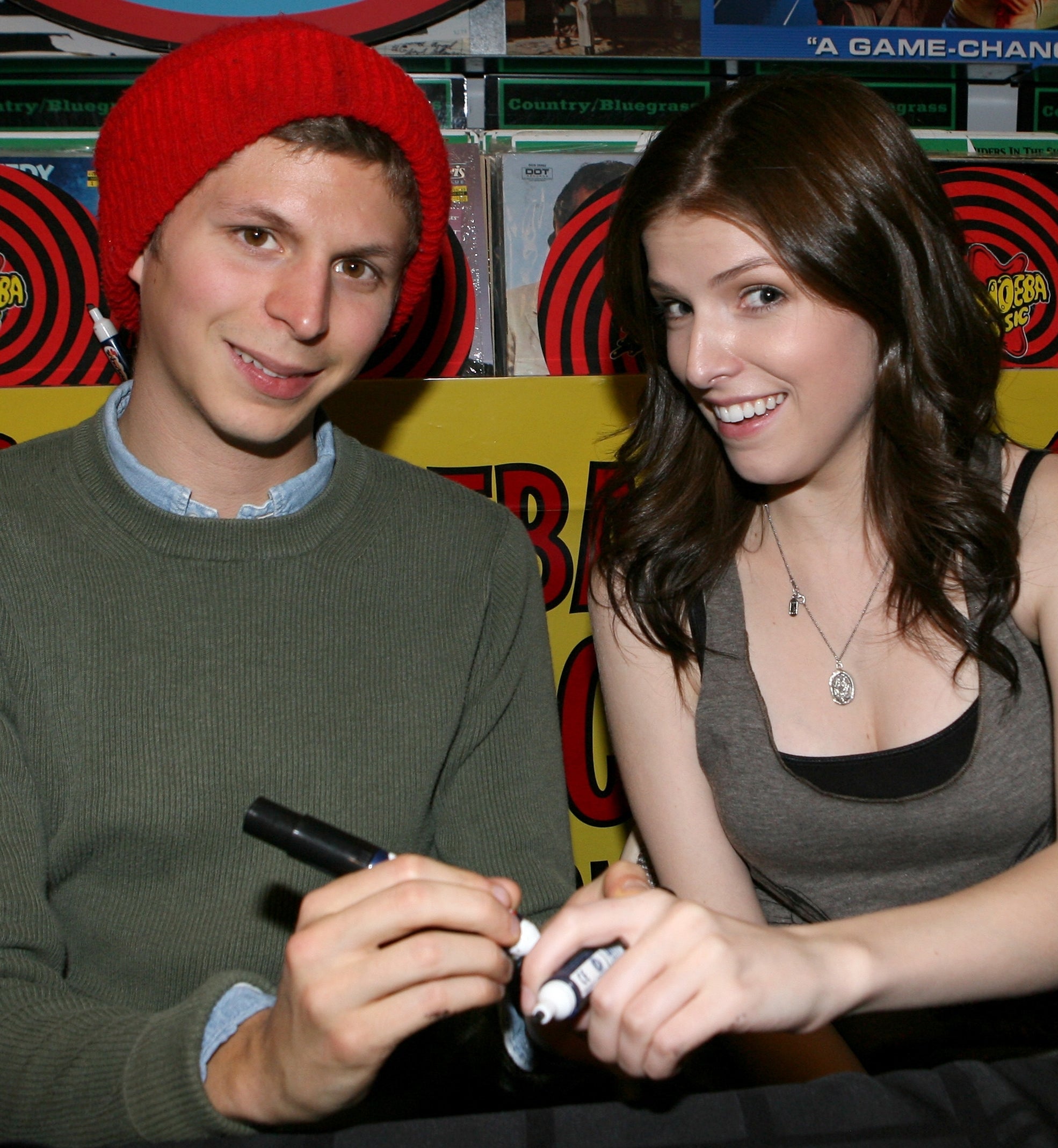 Michael and Anna smiling and signing autographs astatine an event