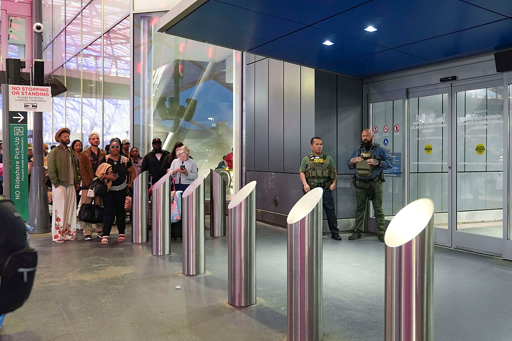 People queue astatine a information checkpoint with 2 guards lasting by