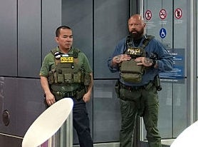 People queue astatine a information checkpoint with 2 guards lasting by