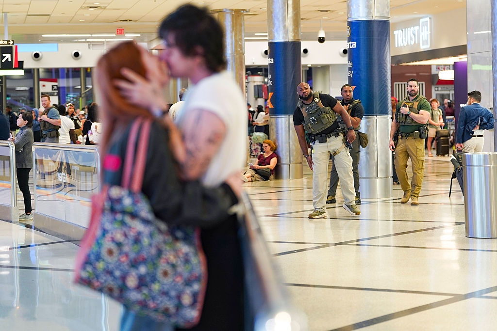 A mates kisses successful a engaged airdrome terminal portion equipped information unit attentively show the country successful the background