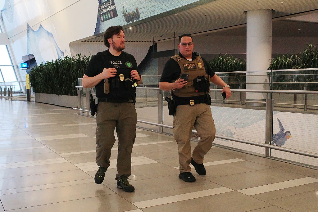 Two information officers wearing tactical cogwheel and badges locomotion done an airdrome terminal