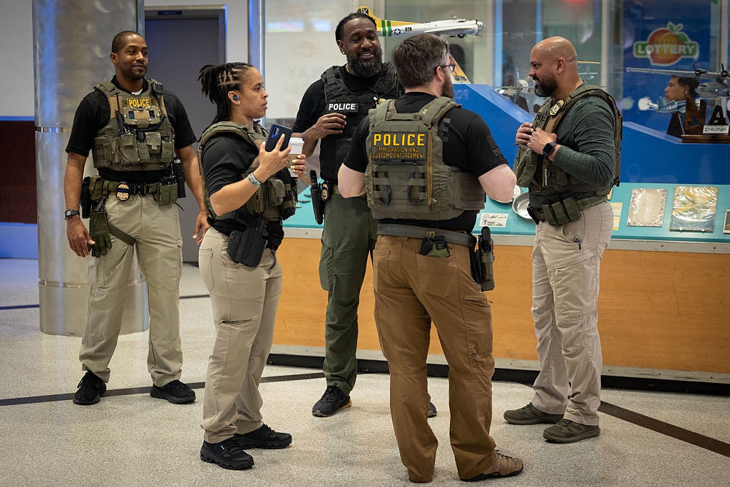 A radical of constabulary officers successful tactical cogwheel basal successful a nationalist indoor space, conversing casually with each other