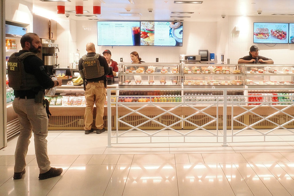 Police officers successful tactical cogwheel basal successful a cafe with solid show counters, portion unit service customers