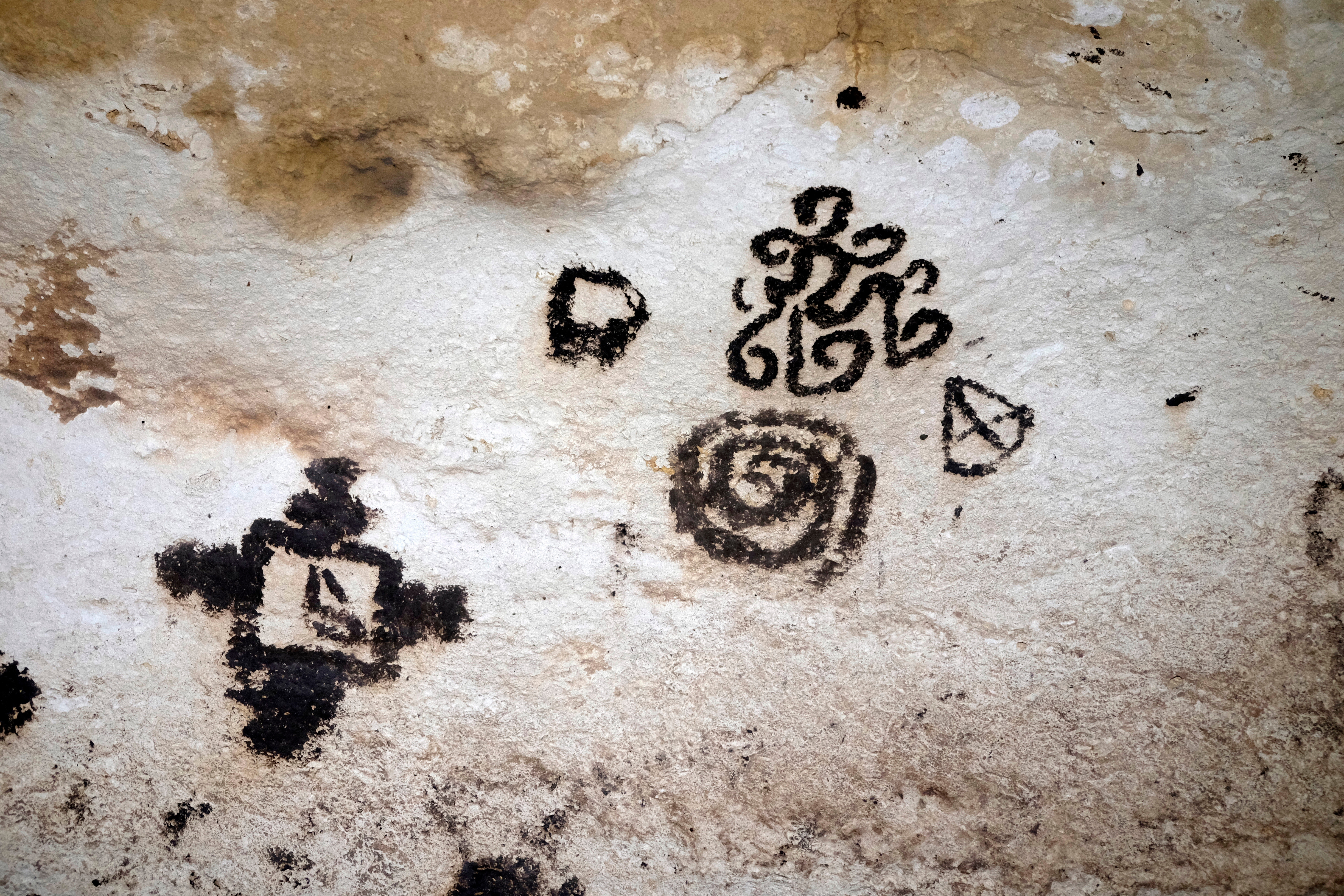 Ancient cave creation featuring abstract, spiraling designs and geometric shapes connected a chromatic surface