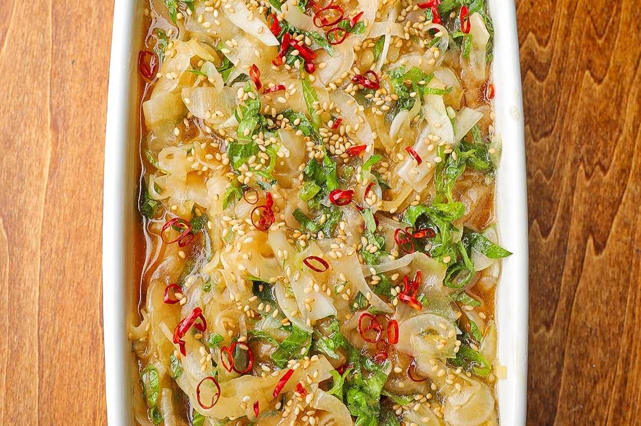 刻んだネギとチリが乗った調理済みの料理が皿に盛られている。