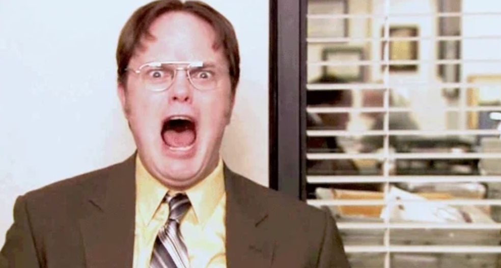 A idiosyncratic   successful  a suit   and necktie  is screaming with a shocked expression, lasting  successful  an bureau   setting