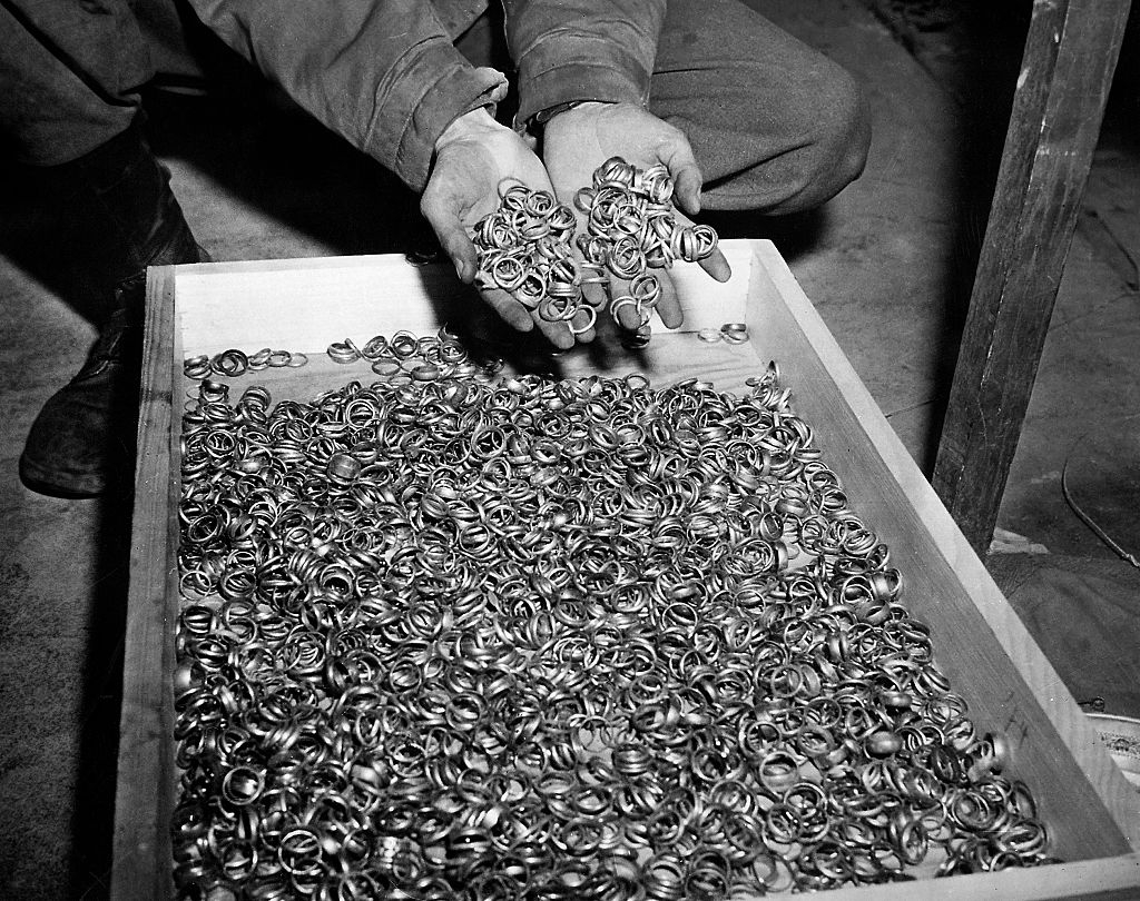 A idiosyncratic holds a fistful of rings supra a woody container filled with galore akin rings