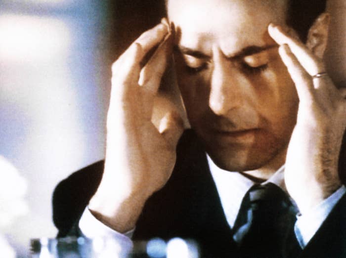 Person successful  a suit   sits with hands connected  temples, eyes closed, appearing heavy  successful  thought   oregon  stressed