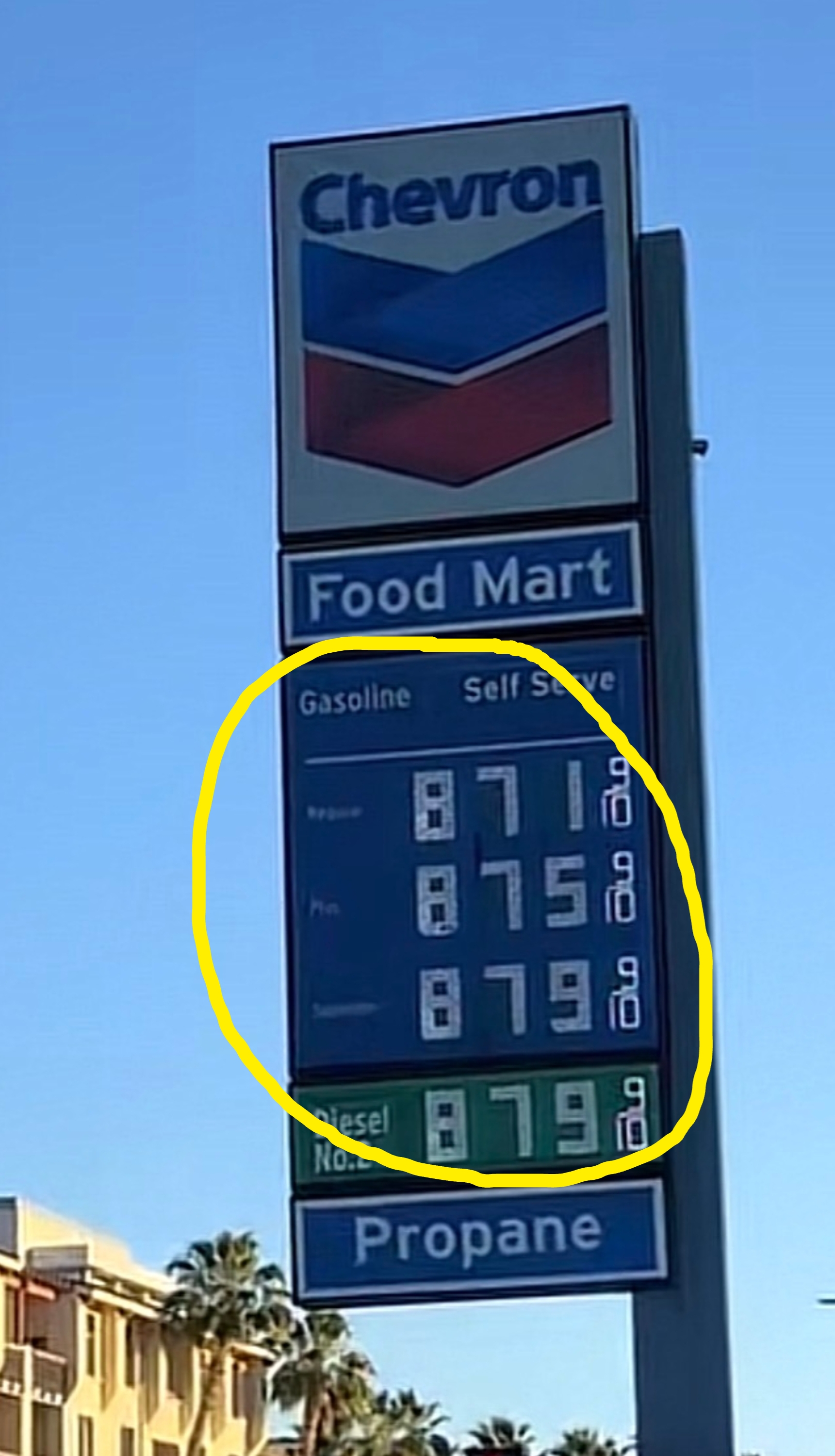 gasoline $8.71, $8.75, $8.79; diesel $8.79. Nearby buildings, thenar  trees, and wide   entity  visible