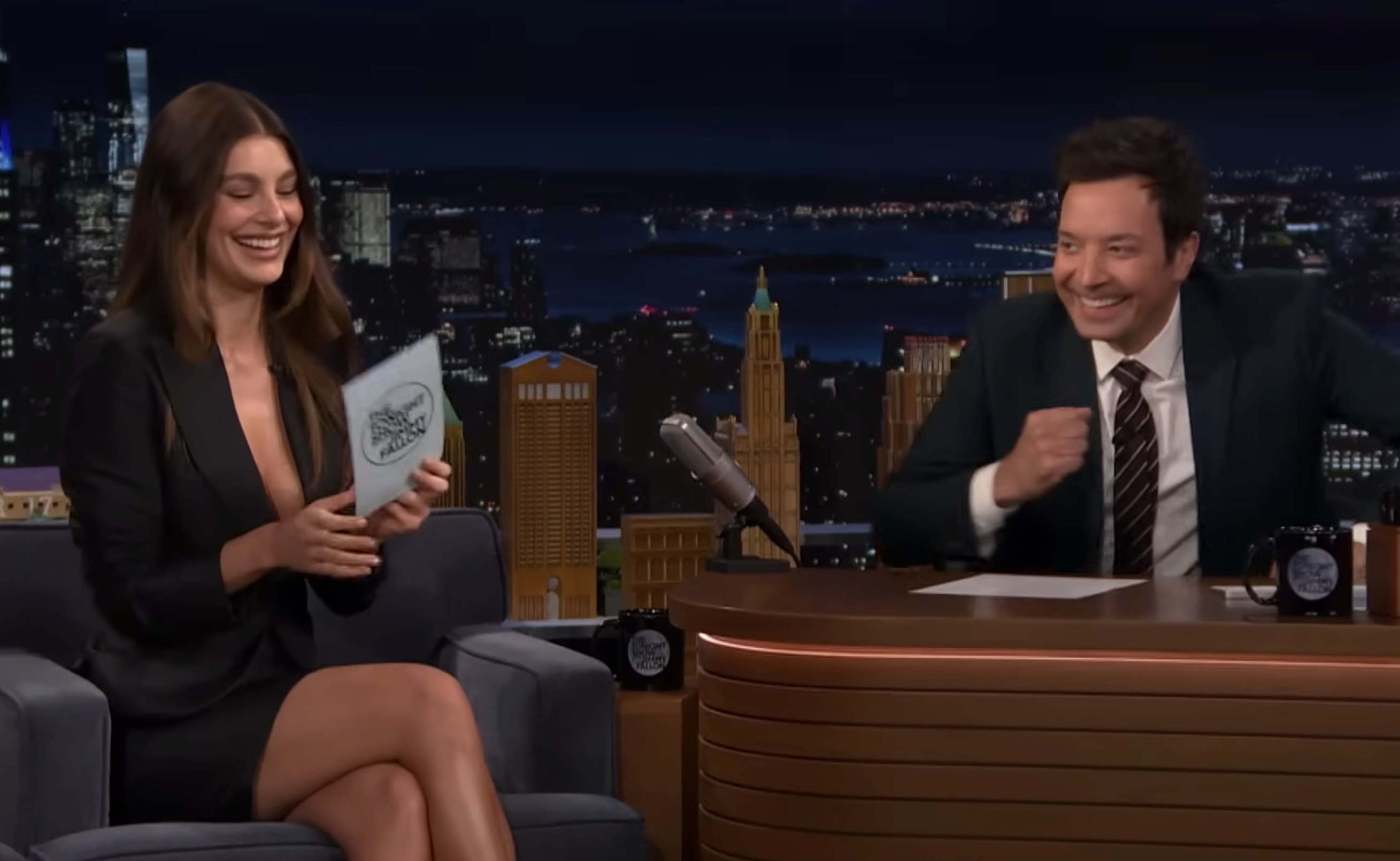 Talk amusement big and impermanent laughter during an interview; impermanent wears a chic blazer dress