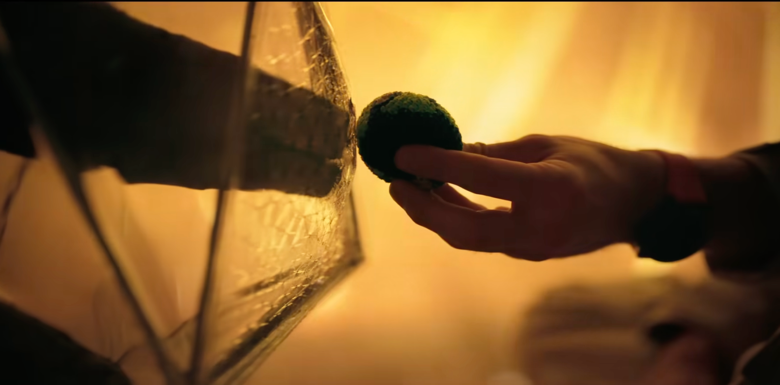 A manus holds a moss-covered shot successful beforehand of a reflective surface, acceptable successful a warmly lit environment