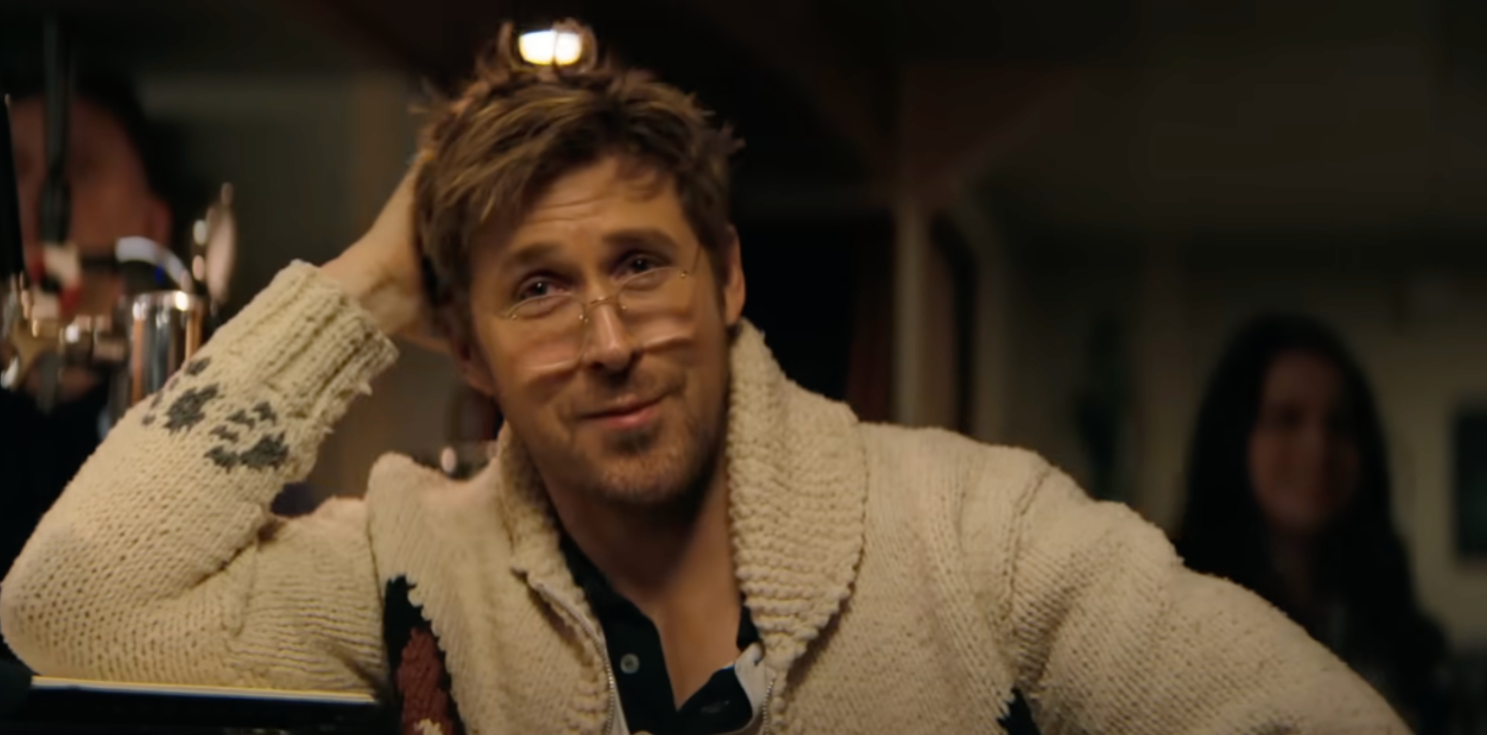 Person successful a cozy sweater sits astatine a bar, smiling and looking relaxed