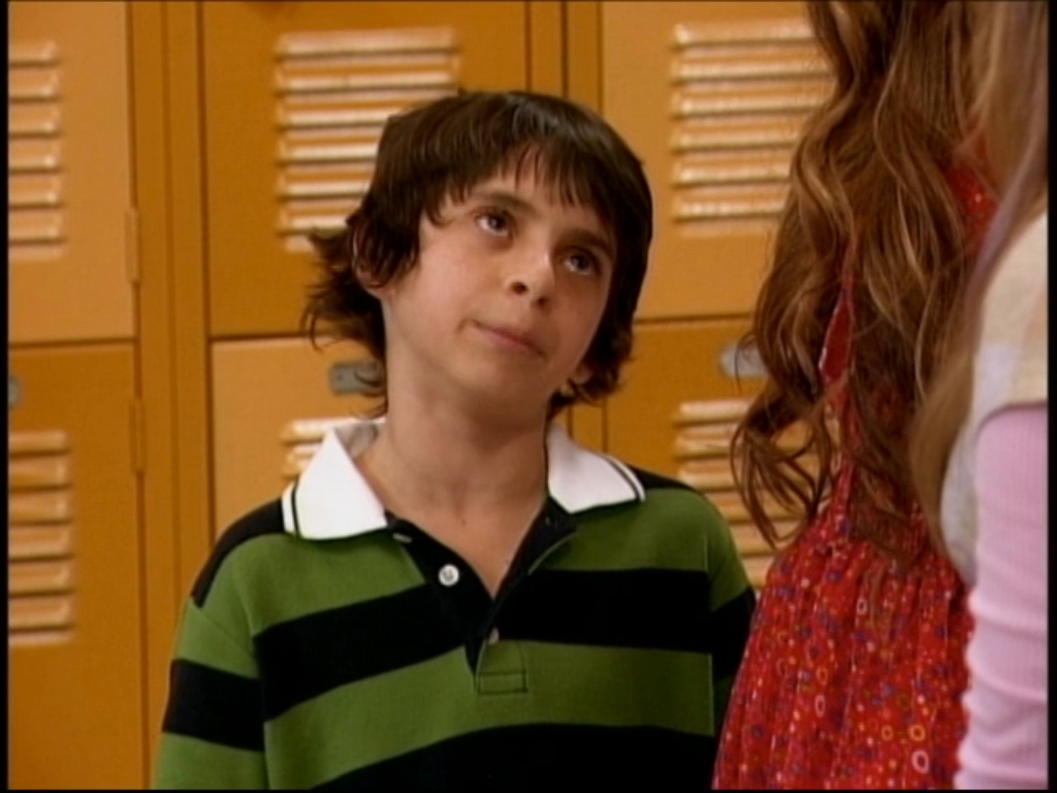 Young lad with striped garment looking up astatine idiosyncratic adjacent schoolhouse lockers