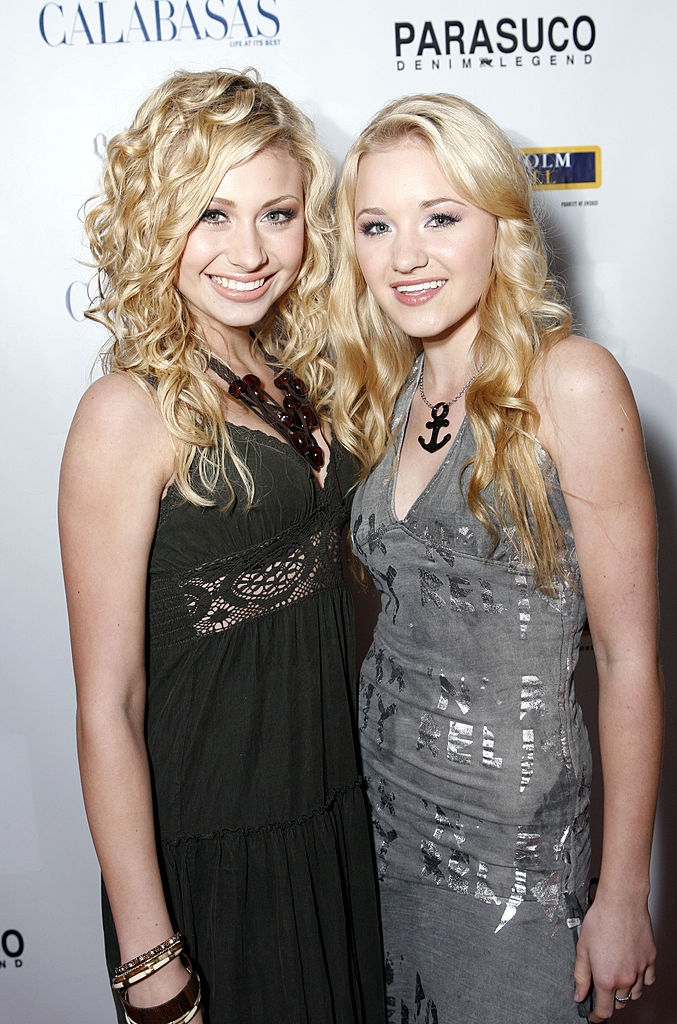 Two radical with long, wavy hairsbreadth posing for a photograph astatine an event, wearing stylish, casual dresses with decorative elements