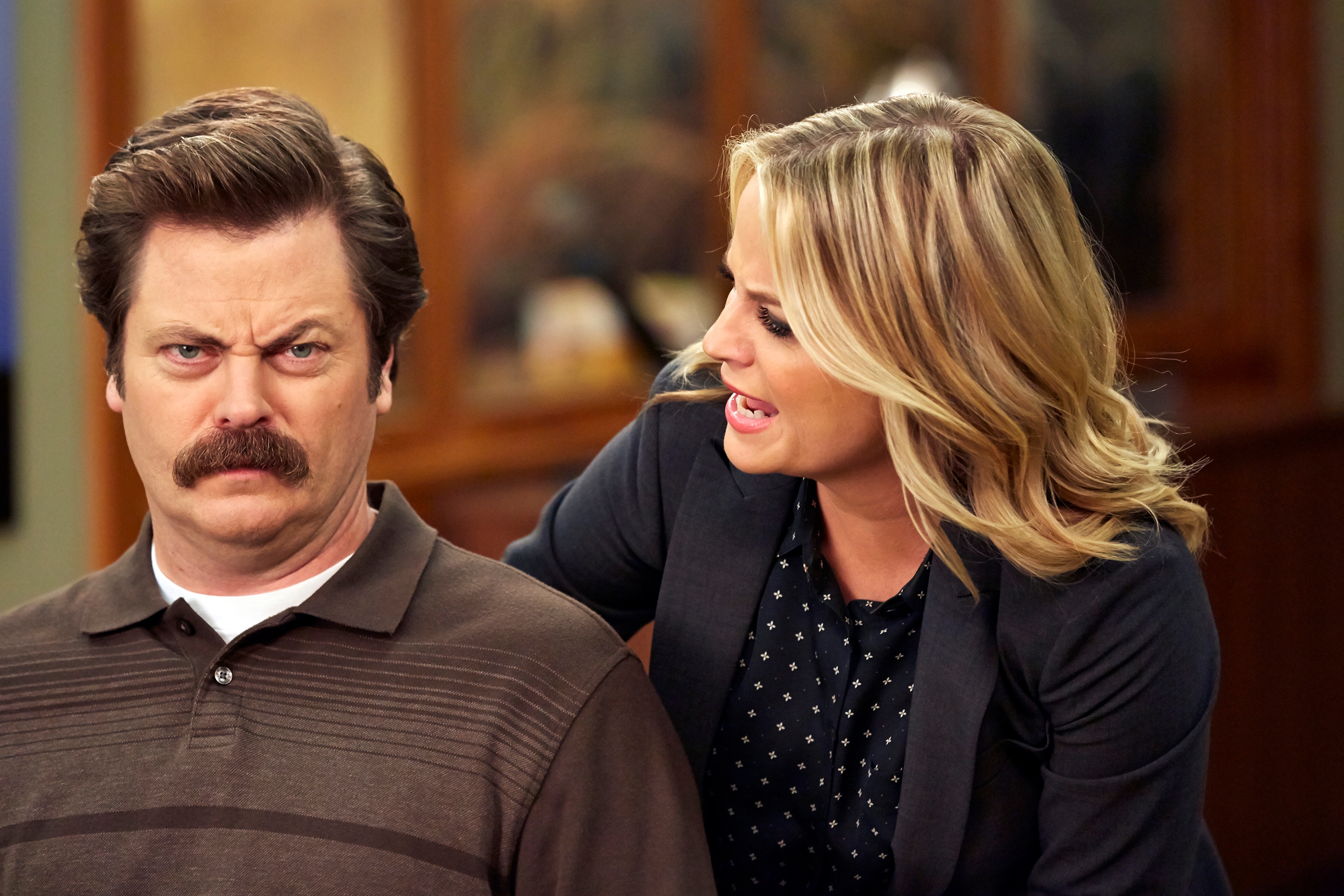 Two radical from a comedic TV scene; 1 looks superior with a mustache, portion the different gestures animatedly, wearing a blazer with a polka dot shirt
