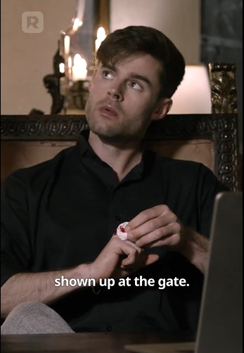 A person in a dimly lit room looks thoughtful, holding a small object, with the caption reading, "shown up at the gate."