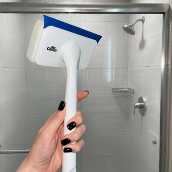 Hand holding a bath cleaning brushwood wrong a shower, showcasing the tool's ergonomic grip and ample scrubbing aboveground for businesslike cleaning