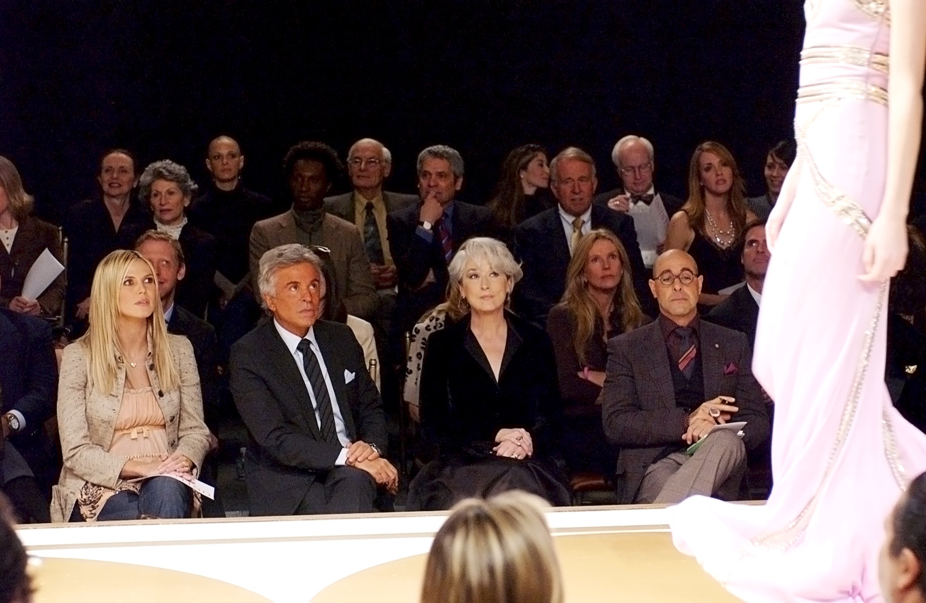 Audience watches a manner show; radical deterioration ceremonial attire. A exemplary successful an elegant formal is connected the runway, partially visible