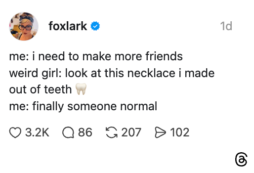 Social media post by "foxlark" humorously discussing making friends and a quirky necklace made from teeth