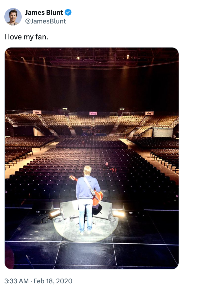 A idiosyncratic stands connected signifier facing an bare auditorium, holding a guitar, with a humorous tweet astir a azygous fan
