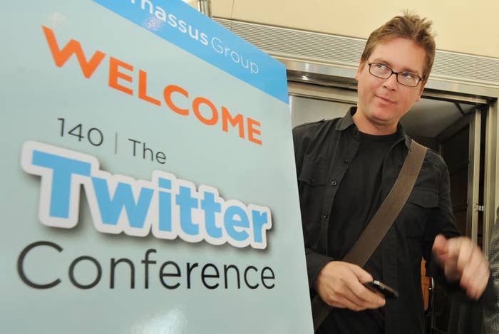 Person astatine  a Twitter Conference, casually dressed with a enarthrosis  bag, stands beside a invited  sign, apt  relating to societal  media discussion