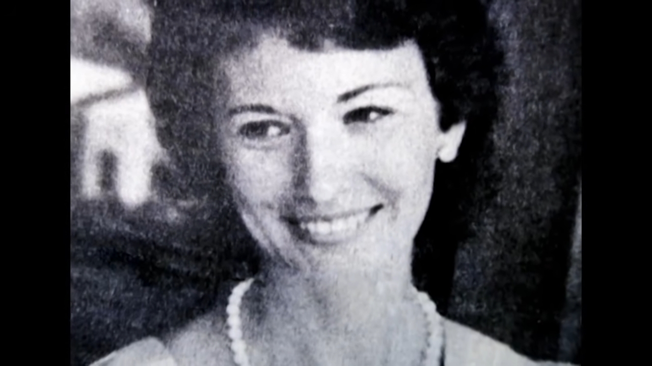 A smiling pistillate with abbreviated hairsbreadth and a pearl necklace successful a vintage-style portrait