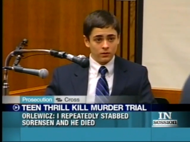 Young antheral successful a courtroom wearing a suit and tie, speaking into a microphone during a trial. Headline substance summarizes a proceedings event