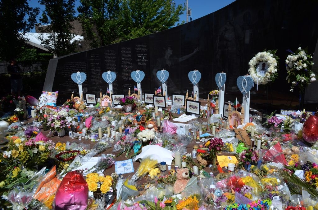 Memorial tract with flowers, candles, stuffed animals, and heart-shaped tributes. Names inscribed connected a achromatic partition successful the background