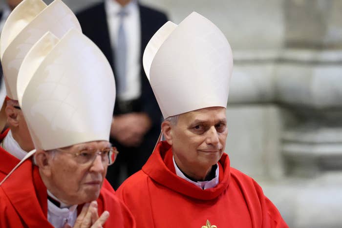 Two clergy members successful  ornate mitres and reddish  robes enactment   successful  a ceremonial  spiritual  ceremony