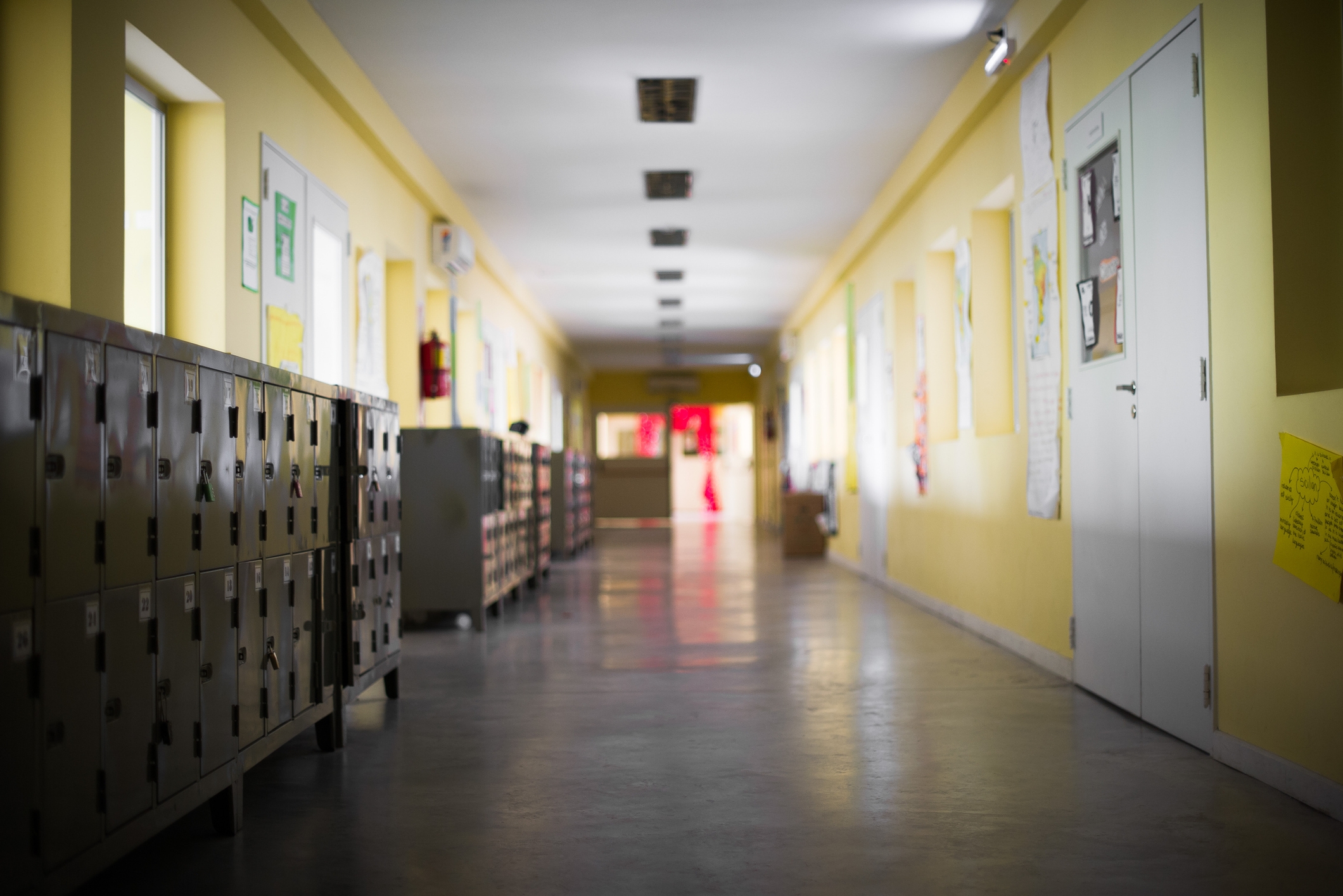 School hallway with lockers and bulletin boards connected the walls, creating a nostalgic, quiescent atmosphere