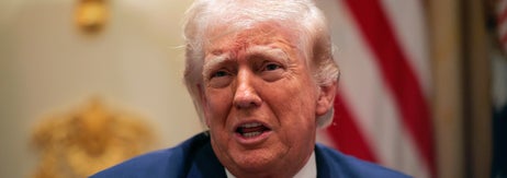 画像の人について詳しくはわかりませんが、スーツと赤いネクタイを着用している男性が話しているシーンです。