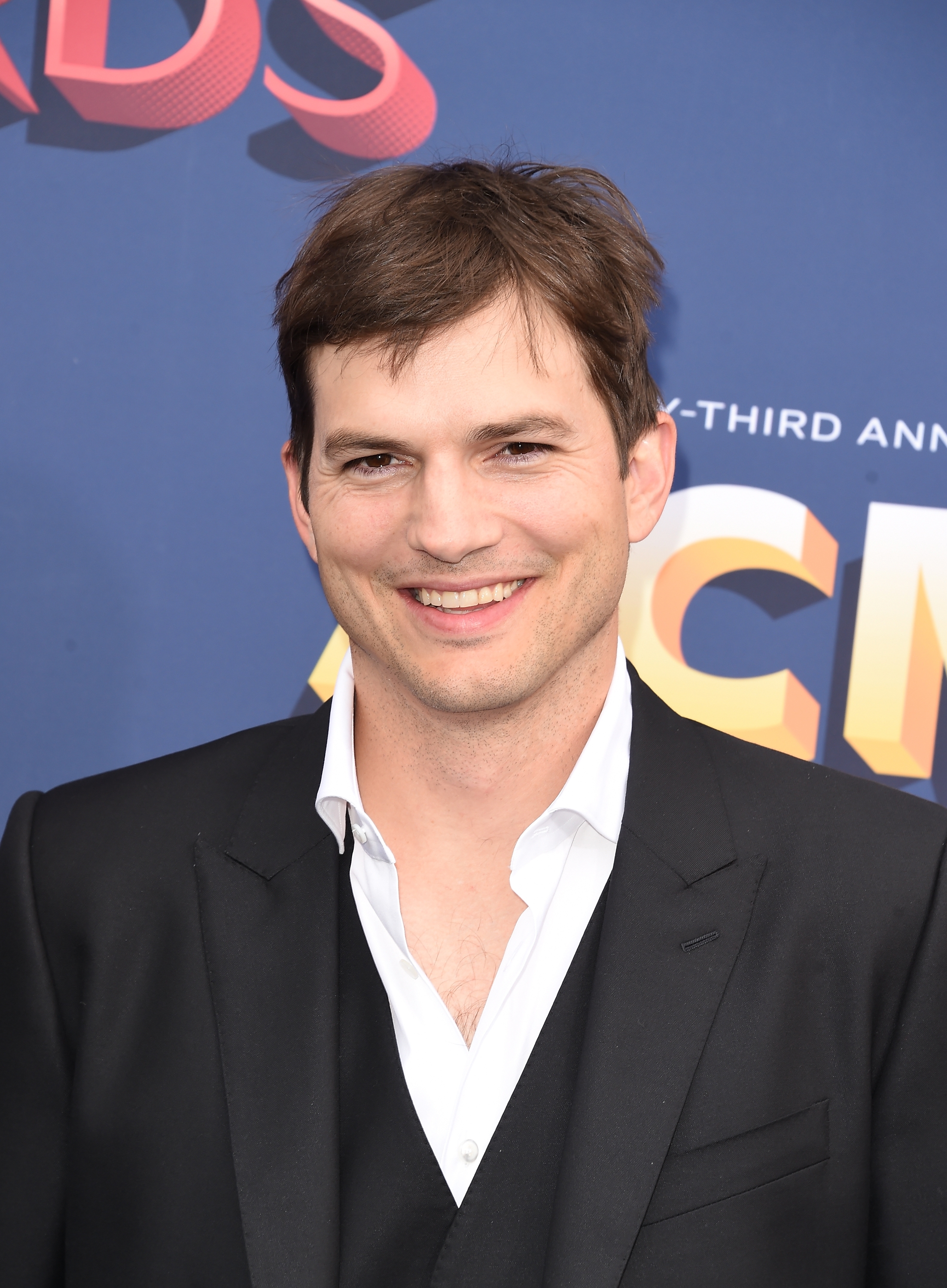 Smiling antheral   successful  a achromatic  suit   overgarment   with a achromatic  shirt, attending a personage  event