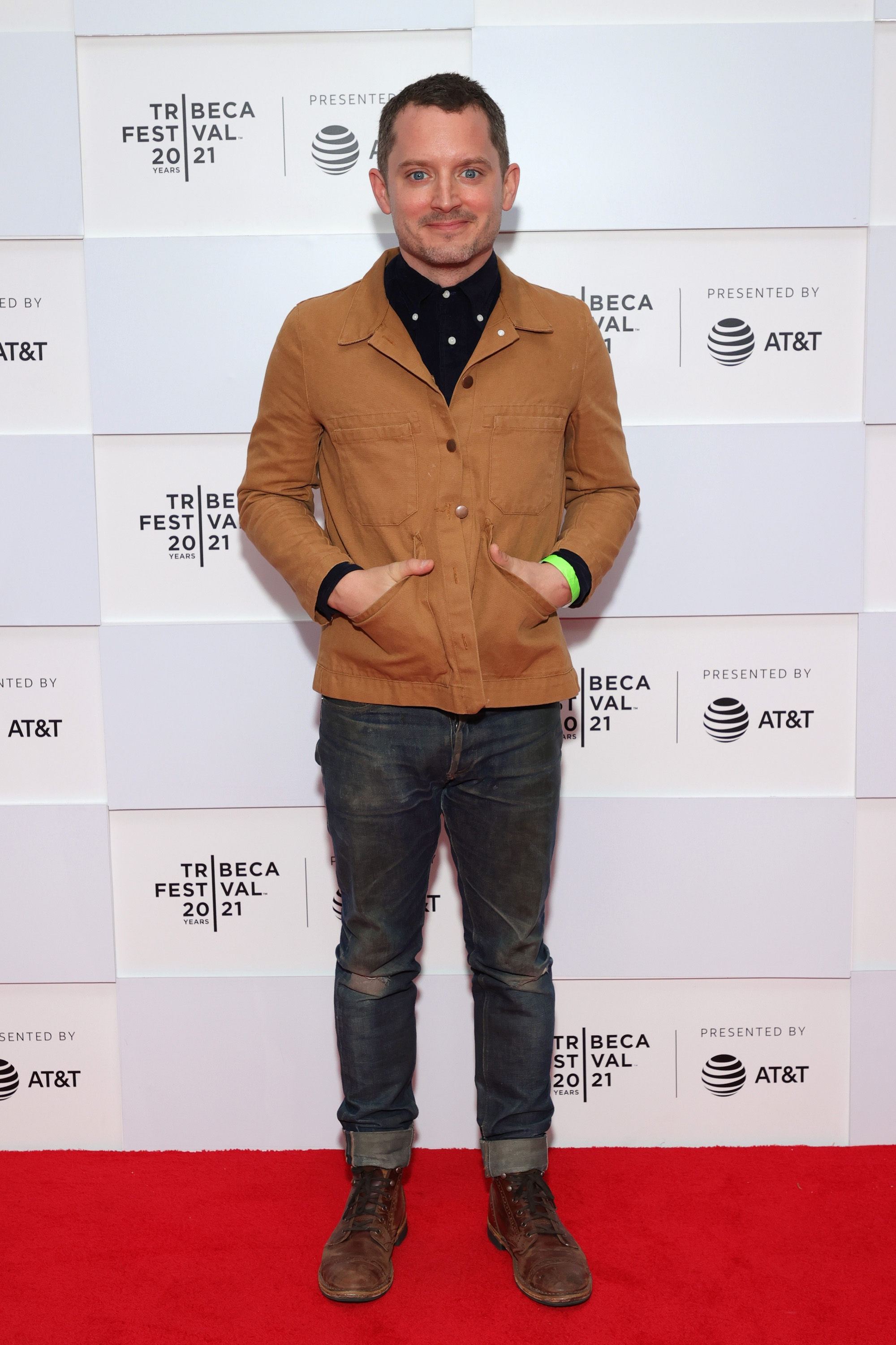 Person successful  casual attire with a brownish  jacket, acheronian  shirt, and jeans, lasting  connected  a reddish  carpet astatine  Tribeca Festival 2021