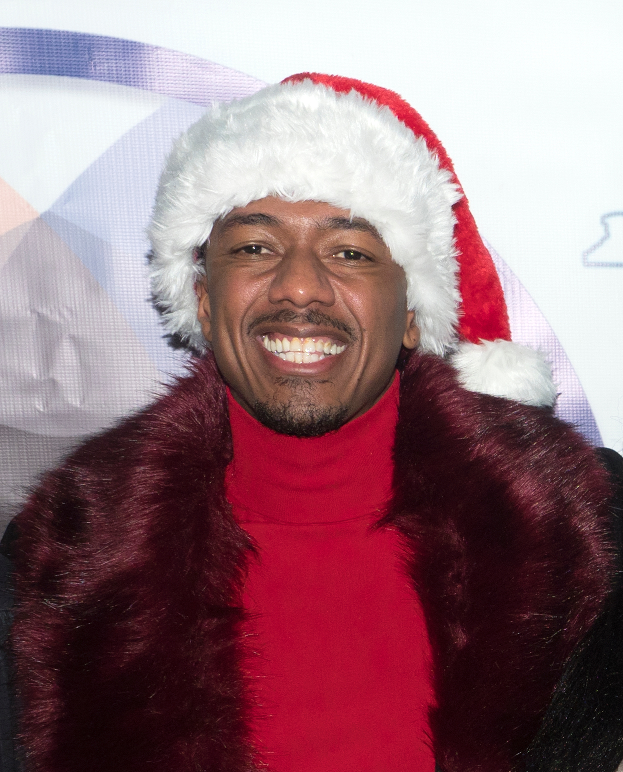 Person smiling, wearing a festive Santa chapeau  and stylish reddish  overgarment  with fur trim, astatine  a personage  event