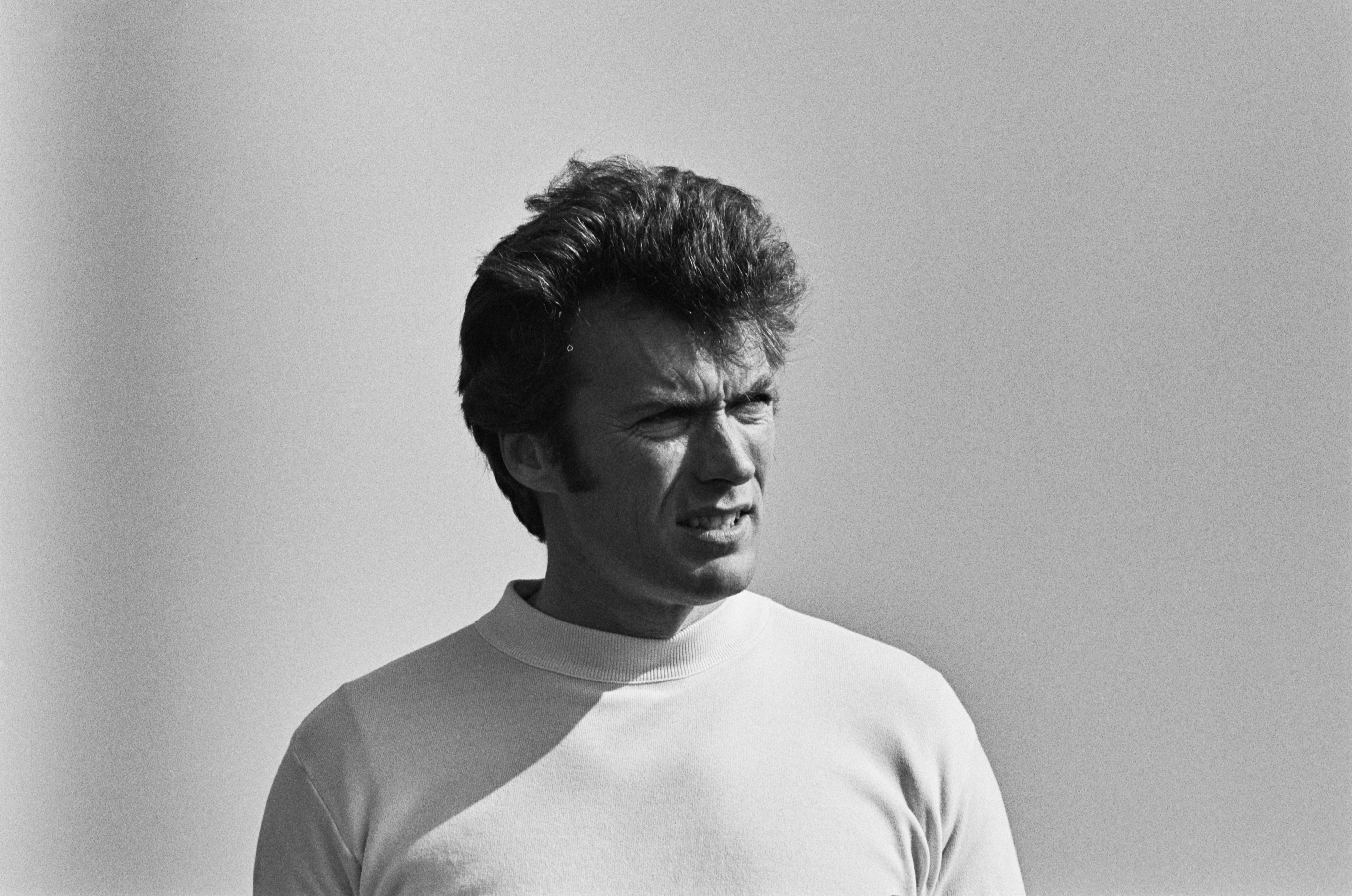 Person successful  a plain turtleneck garment  gazes into the distance, with a neutral background