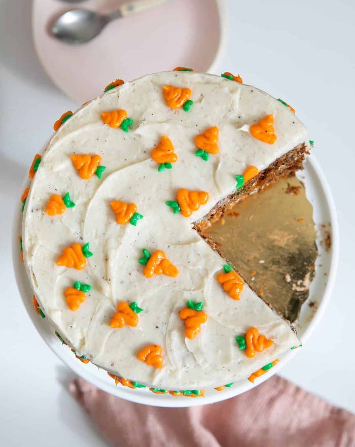 Carrot barroom   with pick  food  frosting, decorated with tiny  piped carrots, 1  portion    missing connected  a achromatic  plate