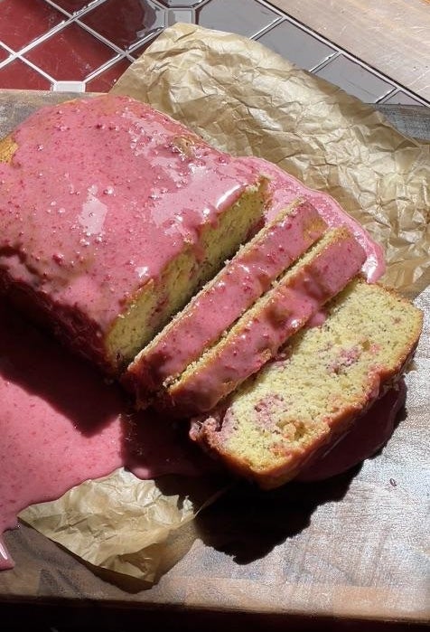 Sliced loaf barroom with pinkish glaze connected parchment paper. Sunlight highlights the glaze texture