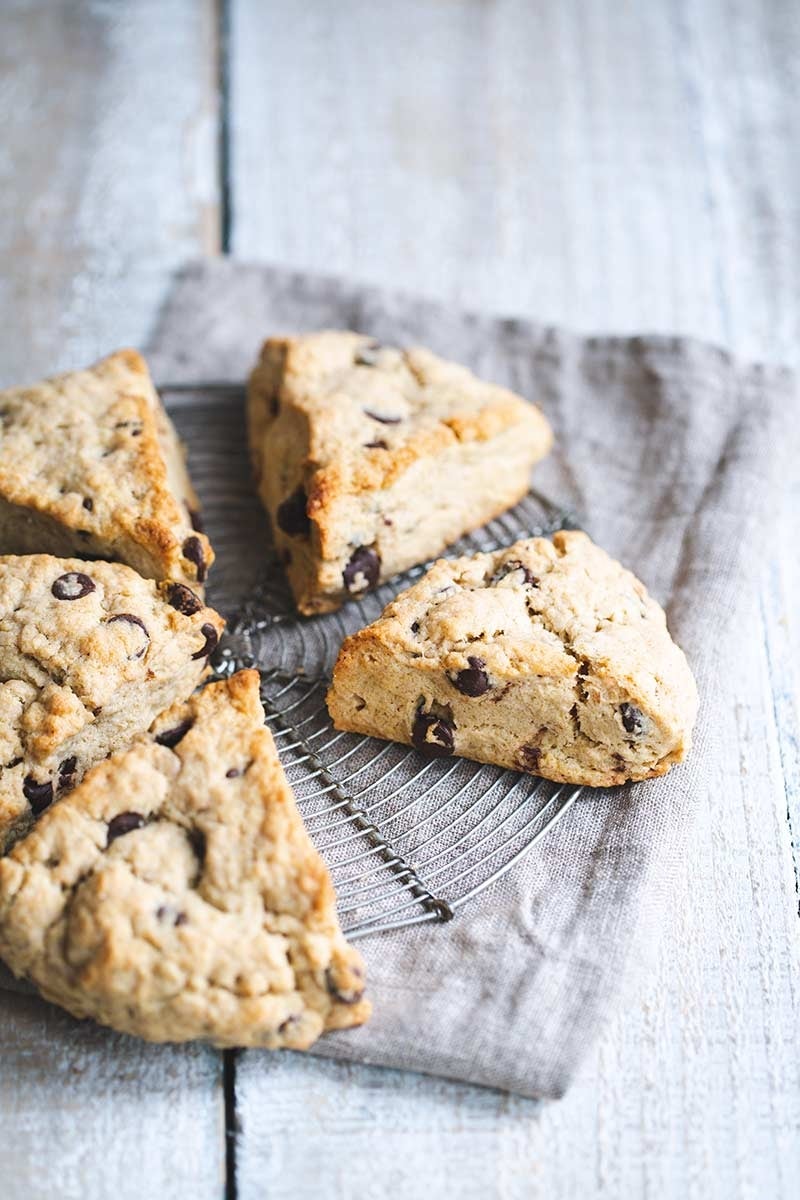 Chocolate chip scones arranged in a circular pattern on a metal cooling rack over a cloth