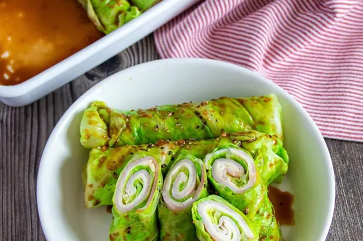 キャベツで巻かれたハムのロールが皿に盛り付けられている。