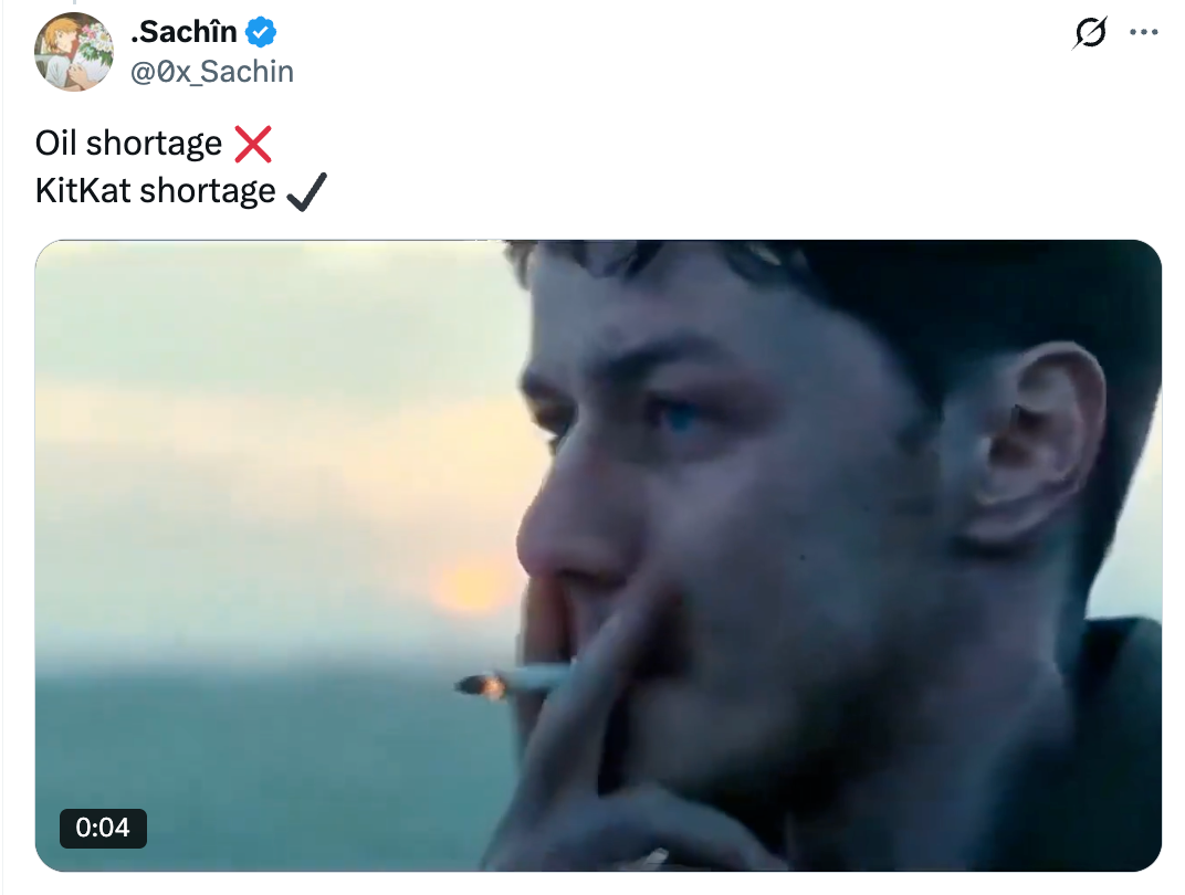 A idiosyncratic smokes a cigaret portion looking into the distance. A tweet supra jokes astir lipid and KitKat shortages