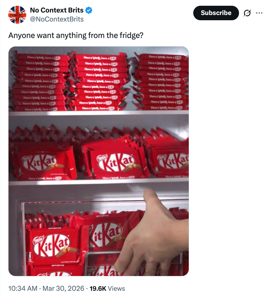 A manus reaches for a KitKat barroom wrong a refrigerator stocked with galore KitKat packages